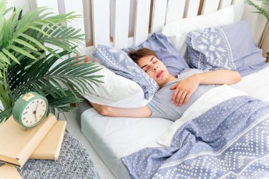 Beyaz odada uyuyan yakışıklı genç