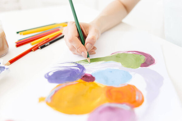 Красивая улыбающаяся молодая женщина рисует картину
