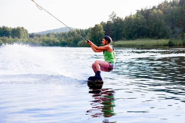 Νεαρό άνδρα ενώ καβαλά wakeboard σε μια λίμνη — Φωτογραφία Αρχείου