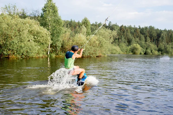 Młody człowiek jazda wakeboard na jeziorze — Zdjęcie stockowe