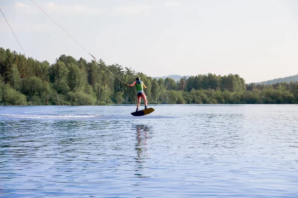 Genç adam bir gölde wakeboard sürme