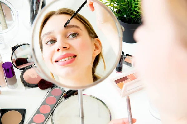 A portrait of woman with makeup brushes near face — Stock Photo, Image