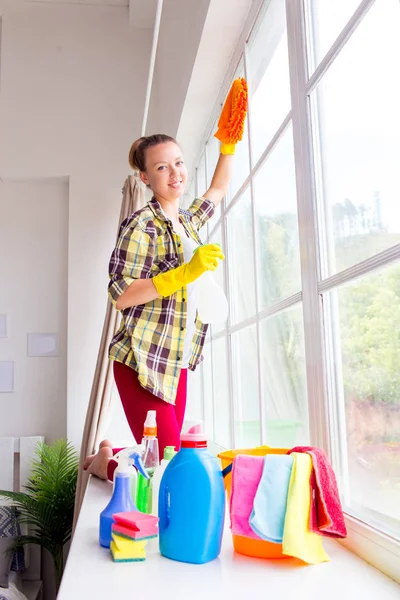 Kvinna i skyddshandskar leende och torka damm med en spray och en duster — Stockfoto