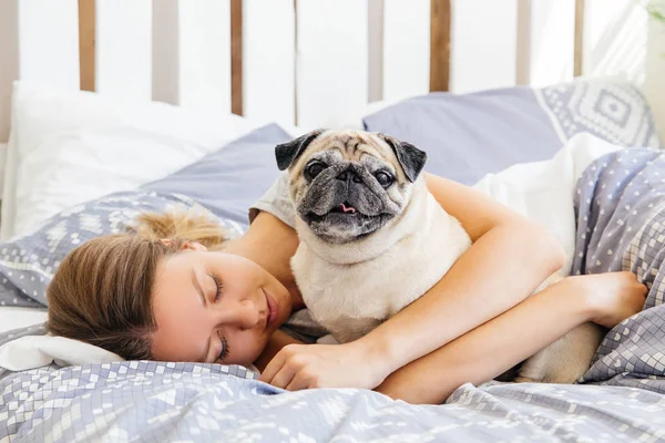 Young woman with her dog in a bed. Breakfast in bed