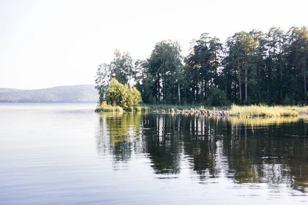 Beautiful campsite on a clear lake with a boat — Stock Photo, Image