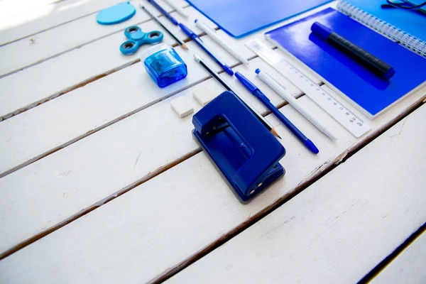 Papel pluma tijeras cuaderno sobre una mesa de madera — Foto de Stock