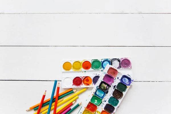 Set aquarel verven en schilderskwast op een tafel — Stockfoto