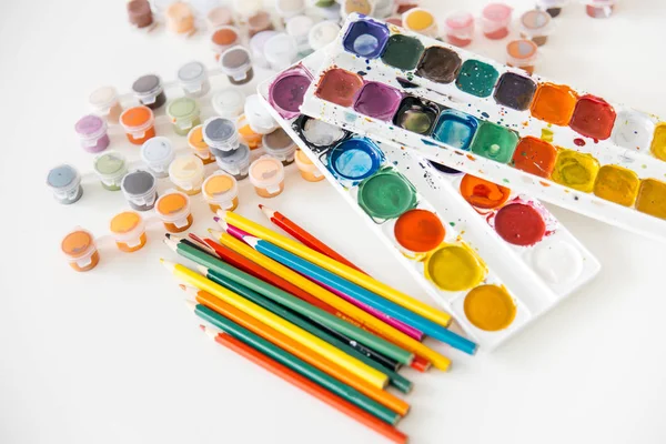 Satz Aquarellfarben und Pinsel auf einem Tisch — Stockfoto