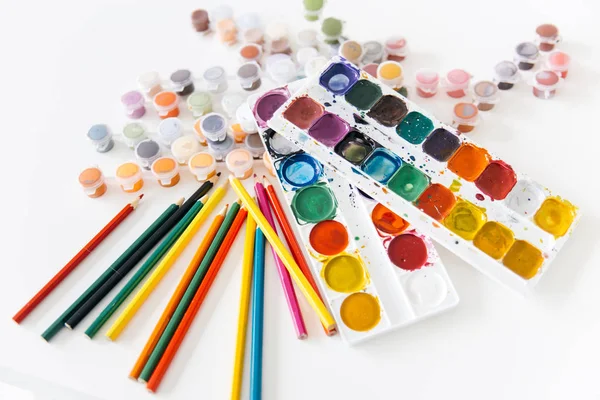 Satz Aquarellfarben und Pinsel auf einem Tisch — Stockfoto