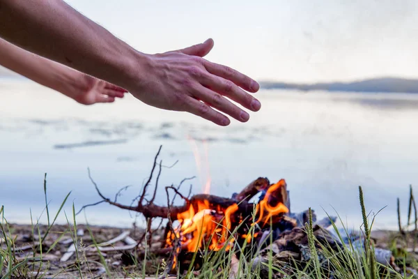 Mooie kampvuur in de avond aan meer. Vuur branden in de schemering op Camping — Stockfoto