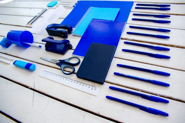Papel pluma tijeras cuaderno sobre una mesa de madera — Foto de Stock