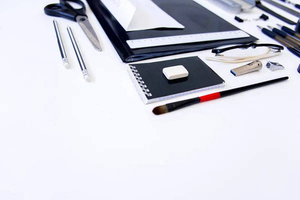 Papel pluma tijeras cuaderno sobre una mesa de madera — Foto de Stock