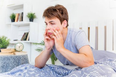 Genç bir adam yatakta sabah uyanma
