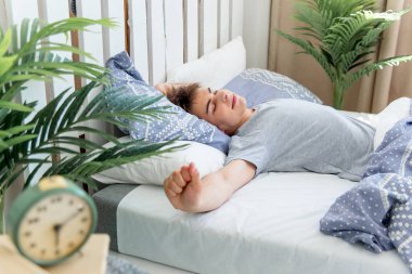 Genç bir adam yatakta sabah uyanma