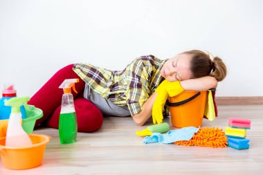 Koruyucu eldiven kadın gülümseyerek ve toz bir sprey ve bir toz bezi kullanarak silme