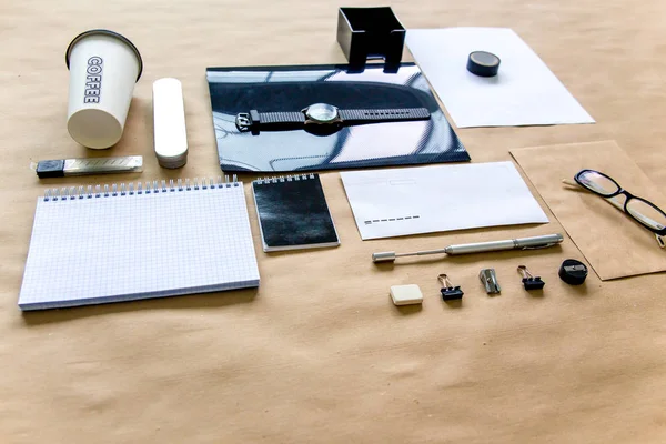 Papel pluma tijeras cuaderno sobre una mesa de madera — Foto de Stock