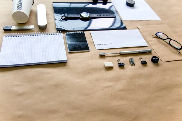 Papel pluma tijeras cuaderno sobre una mesa de madera — Foto de Stock