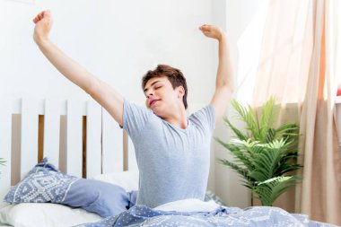 Genç bir adam yatakta sabah uyanma