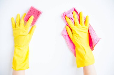 Koruyucu eldiven kadın gülümseyerek ve toz bir sprey ve bir toz bezi kullanarak silme