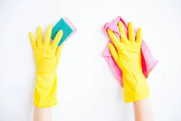 La mujer con guantes protectores sonríe y limpia el polvo con un aerosol y un plumero — Foto de Stock