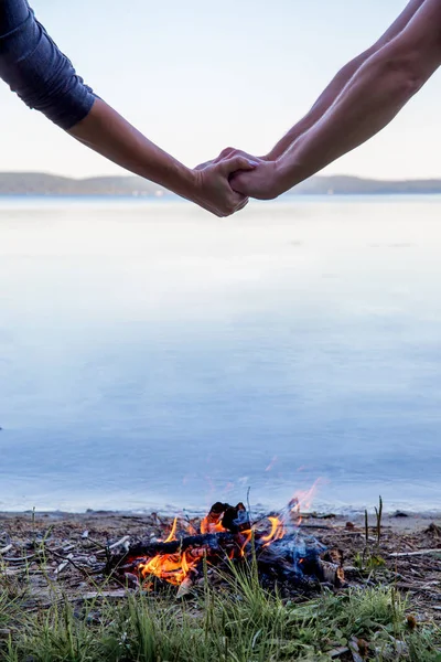 Schönes Lagerfeuer am Abend am See. Feuer brennt in der Dämmerung auf Campingplatz — Stockfoto