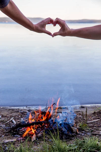 Hermosa fogata en la noche en el lago. Fuego ardiendo en el atardecer en el camping — Foto de Stock