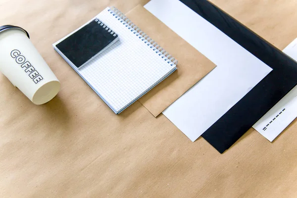 Papel pluma tijeras cuaderno sobre una mesa de madera — Foto de Stock
