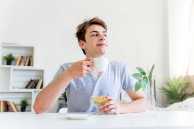 Genç adam içme kahve ve having kahvaltı