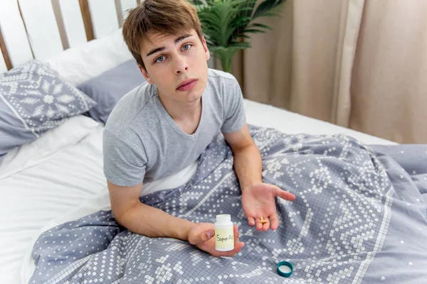 Man waking up late for work early. Funny bed concept with young man oversleeping