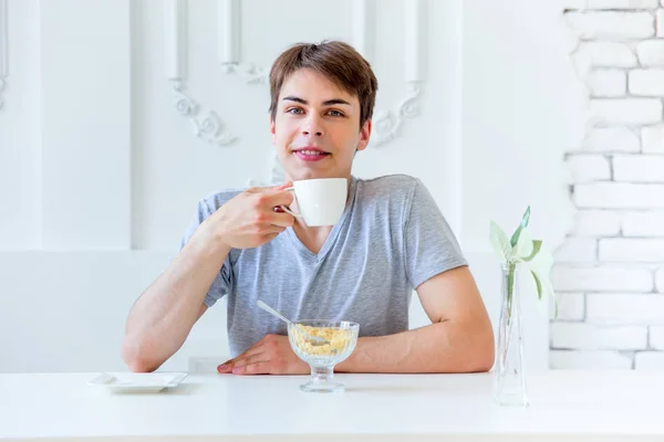 Young man drinking coffee and having breakfast — Stock Photo, Image
