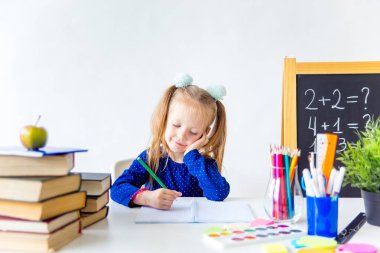 Mutlu sevimli çalışkan çocuk bir masada kapalı oturuyor
