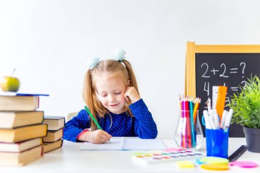 Mutlu sevimli çalışkan çocuk bir masada kapalı oturuyor