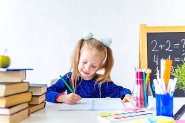 Mutlu sevimli çalışkan çocuk bir masada kapalı oturuyor