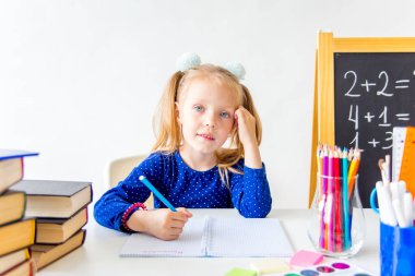 Mutlu sevimli çalışkan çocuk bir masada kapalı oturuyor