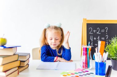 Mutlu sevimli çalışkan çocuk bir masada kapalı oturuyor