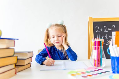 Mutlu sevimli çalışkan çocuk bir masada kapalı oturuyor