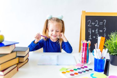 Mutlu sevimli çalışkan çocuk bir masada kapalı oturuyor