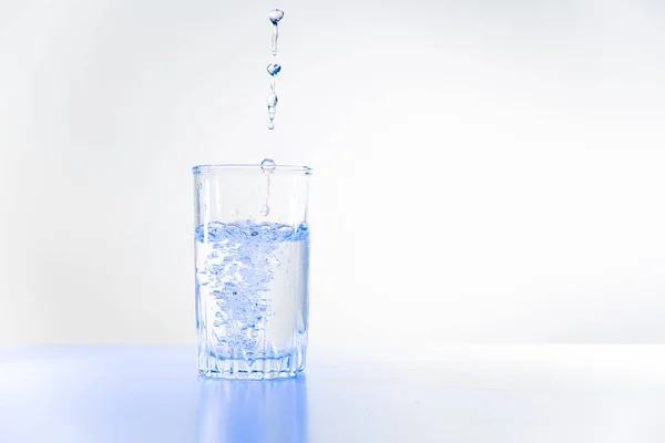 Bicchiere di acqua pura su un tavolo da cucina bianco — Foto Stock