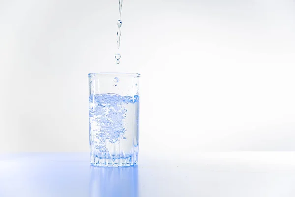 Bicchiere di acqua pura su un tavolo da cucina bianco — Foto Stock