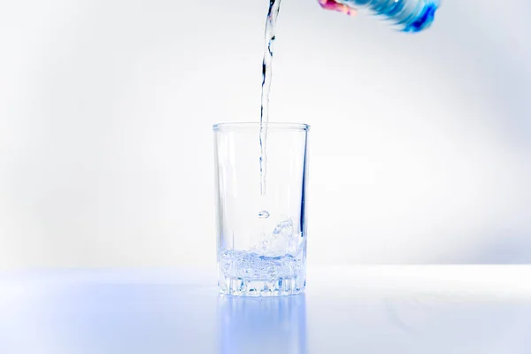Glass of pure water on a white kitchen table