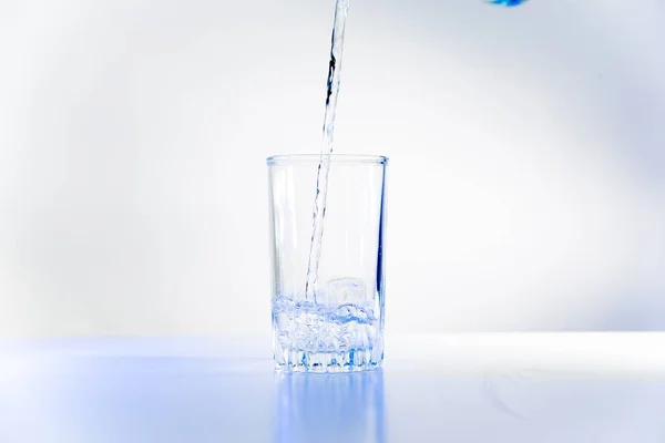 Üveg-tiszta víz-fehér konyhaasztalon — Stock Fotó
