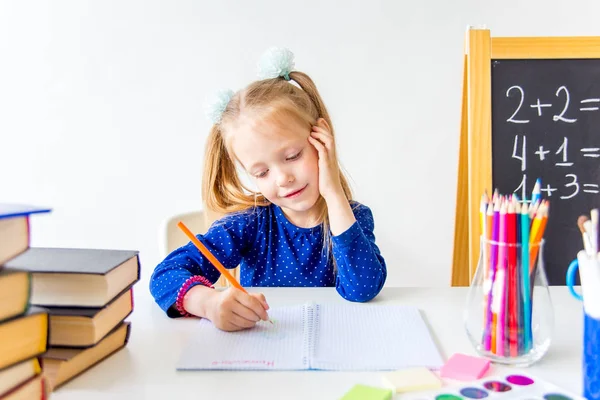 Mutlu sevimli çalışkan çocuk bir masada kapalı oturuyor