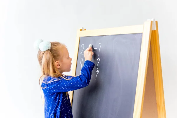 Glückliches nettes fleißiges Kind sitzt drinnen am Schreibtisch — Stockfoto