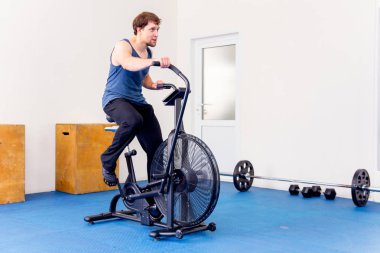 Bir spor salonunda CrossFit egzersiz yapan genç kaslı erkek