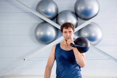 Kettlebell ve ip ile bir spor salonunda CrossFit egzersiz yapan genç kaslı erkek