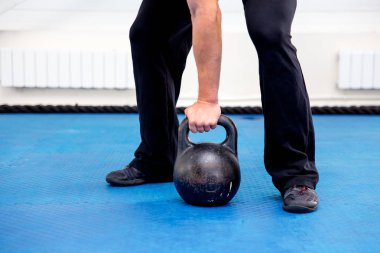 Bir spor salonunda CrossFit egzersiz yapan genç kaslı erkek