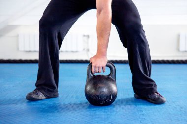 Bir spor salonunda CrossFit egzersiz yapan genç kaslı erkek