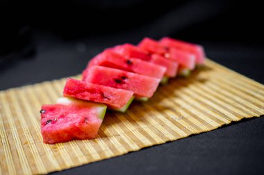 bir taze görüntüsünü kırmızı sulu karpuz bir masanın üzerine dilimlenmiş.