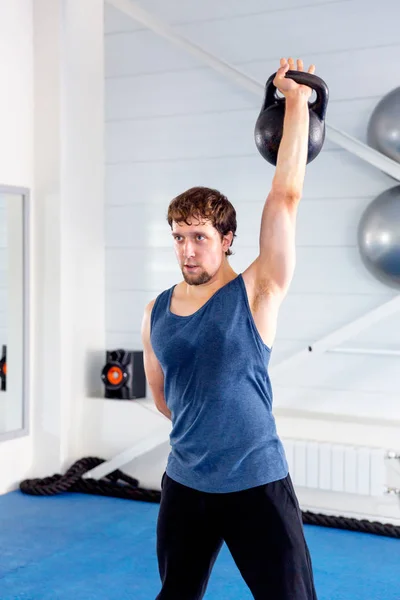 Jovem homem musculoso fazendo exercícios crossfit em um ginásio — Fotografia de Stock