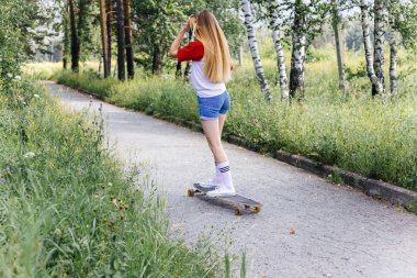 Onun longboard şehir sürme güzel patenci kadın